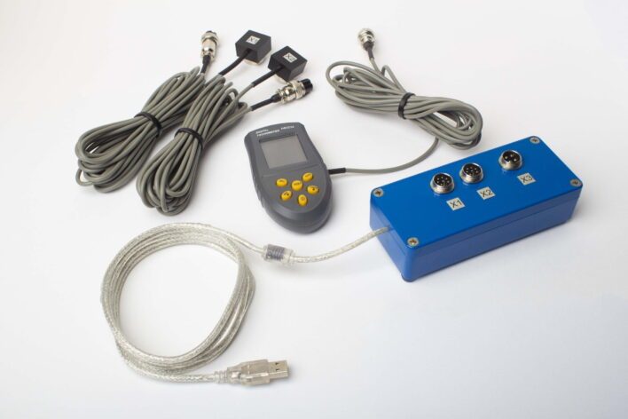 Vibroanalizador portátil Balanset-1A con su unidad de medida USB de dos canales sobre la mesa junto a un portátil